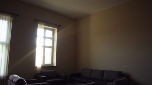 Pereți înalți și goi într-o cameră românească.